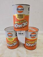 Front view of three Gulf 10W-30 cans showing logos and grade