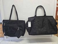 Front view of large duffel, medium tote and small pouch