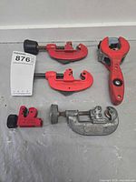 Five tubing cutters laid out on surface