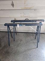 Pair of blue folding sawhorses fully extended