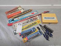 Entire assortment laid out showing packaged bits, loose augers, Mastercraft box and lot ticket