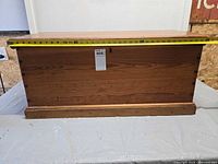 Front view of pine toolbox with measuring tape across width