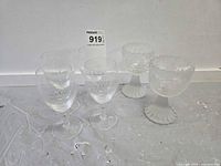 Six stemmed glasses: four clear with Irish Coffee print, two frosted with embossed design
