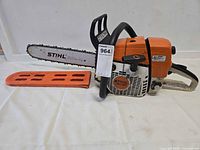 Left side view of Stihl MS 361 chainsaw with bar scabbard attached