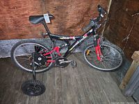 Side view of Supercycle XTL-18 DS bicycle showing overall condition, graphics, and training wheels