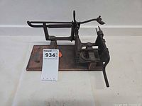 Side view of cast iron apple peeler on wood base showing gears and crank