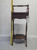 Front view of wood smoker stand with tape measure showing height approx. 32 in, drawer closed, handle and turned legs visible