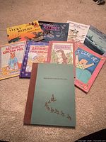 Group shot showing all eight children's books spread on carpet