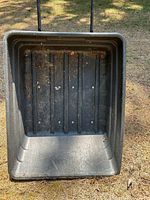 Top view inside black poly tub showing ribbed floor and scuffs
