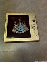 Front of ornament inside branded ChemArt box