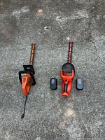 Both hedge trimmers side-by-side with two battery packs