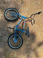 Full view of blue Huffy bicycle laying on ground