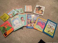 All 11 books laid out on carpet showing front covers