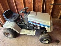 Full left side view of MTD LT 12.5-38 tractor showing seat, steering wheel, body and flat rear tire
