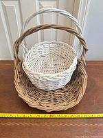 Both baskets nested together showing color difference and measuring tape for scale