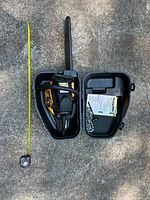 Chainsaw inside open case with tape measure for scale