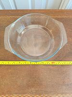 Top view showing full round glass dish and measuring tape indicating diameter