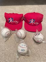 Two red caps and five sealed commemorative baseballs