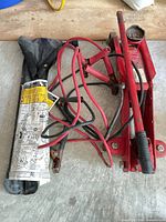Trolley jack, jumper cables, handle, pouch on floor