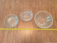Top view of three glass bowls side-by-side with measuring tape for scale