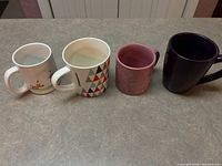 Front view showing all four mugs and designs