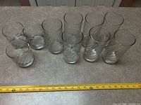 Group of drinking glasses on countertop with measuring tape for scale