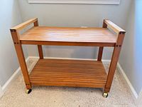 front view of two-tier wooden cart on casters
