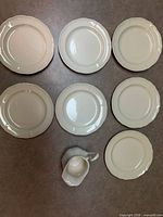 Top-view showing seven plates and creamer for item count and pattern
