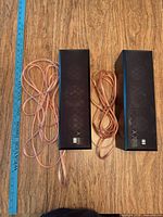 Front view of both Yamaha NS-M125 speakers with attached wires