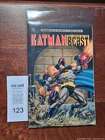 Front view of bagged trade paperback showing full cover art and lot tag 123