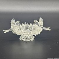 Top and side view showing clear glass bowl, bird handles, ruffled rim, footed base