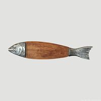 Full view of fish-shaped board showing wood body and metal head and tail
