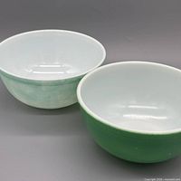 both Pyrex green mixing bowls side by side showing size difference and interior color