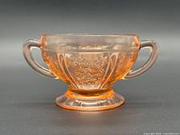 front view of pink Depression glass sugar bowl showing handles and rose pattern