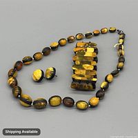 Full view of necklace, bracelet and earrings showing design, colour and condition