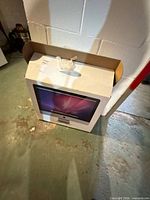 Retail white Apple iMac box with handle leaning against wall