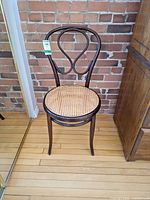 Front view showing bentwood frame, looped backrest and cane seat