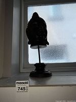 Full view of Buddha head bust on stand