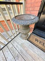 Full view of cast iron urn on porch showing overall style and condition