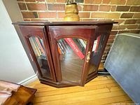 Front view of curio cabinet showing glass doors and dark cherry finish