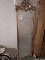 Full view of mirror wrapped in bubble wrap leaning against wall