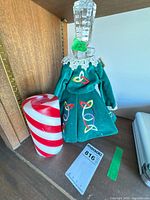 Decanter with stopper dressed in green velvet cover beside red and white pillar candle