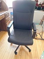 Front view of black IKEA Millberget office chair showing seat, backrest, armrests and caster base