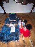 All items grouped: open jewelry box with contents, blue faux fur stole, red feather mules