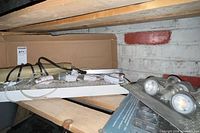Shelf holding NOMA light bar, GU10 bulbs, loose sockets and cords
