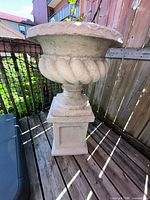 Full view of urn planter on pedestal