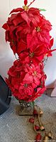 Full view of stacked red poinsettia arrangement in metal urn planter