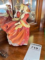 Full figurine on wooden surface with mirror reflection