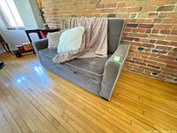 Front view of gray microfiber sleeper sofa with accessories