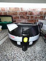 Front view of black T-fal ActiFry Original air fryer showing handle, lid and exterior condition